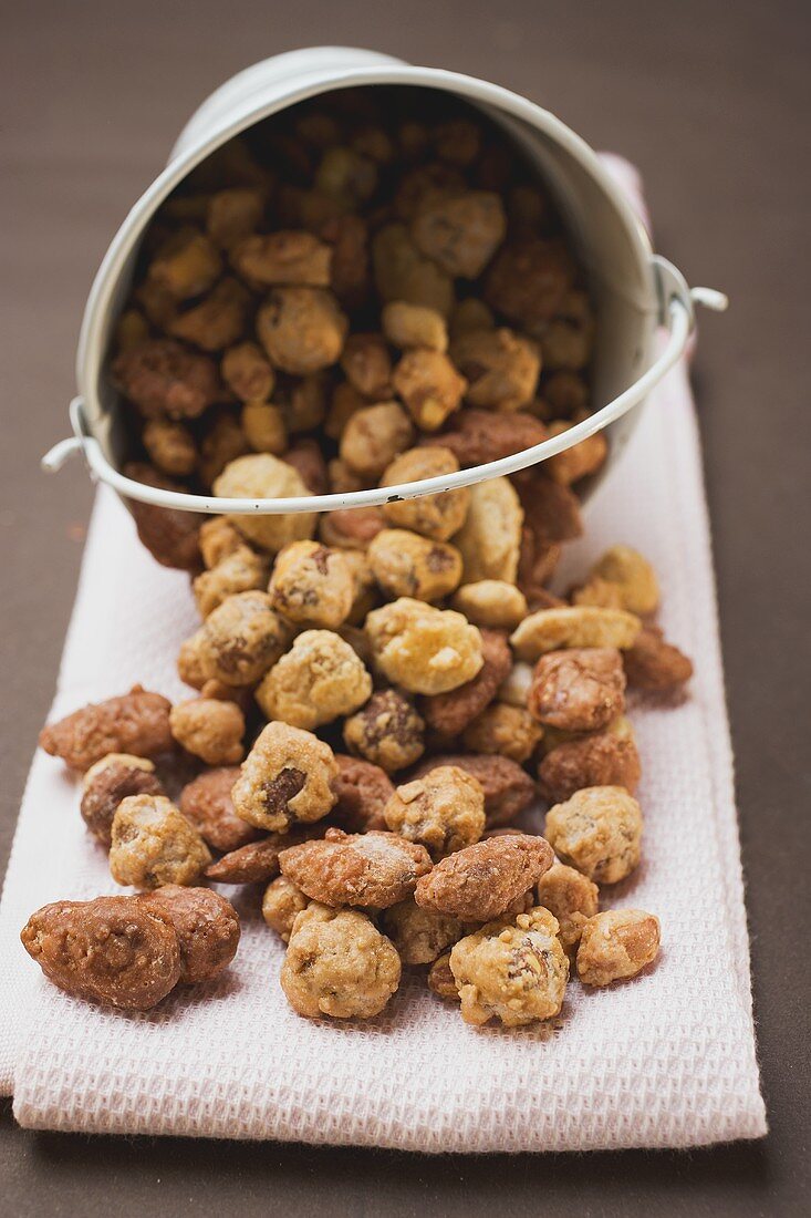 Mixed nuts to nibble in and in front of white bucket