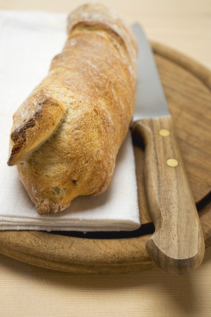 Baguette auf Holzteller mit Messer