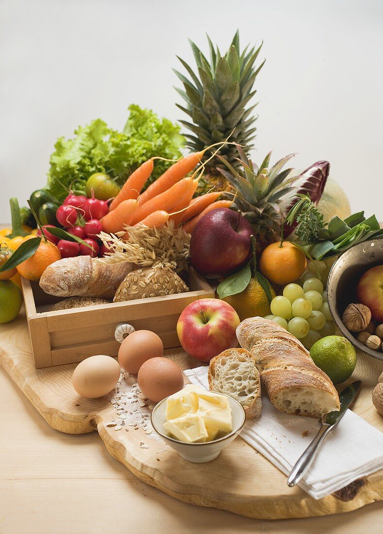 Stillleben mit Gemüse, Obst, Eiern, Butter und Vollwertbrot