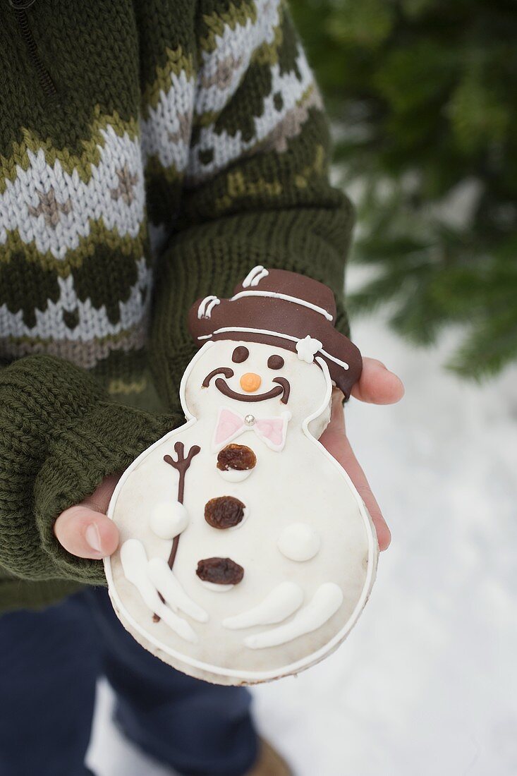 Kind hält Schneemannplätzchen