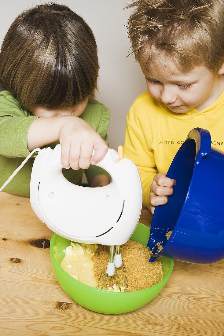 Zwei Kinder bereiten Rührteig zu