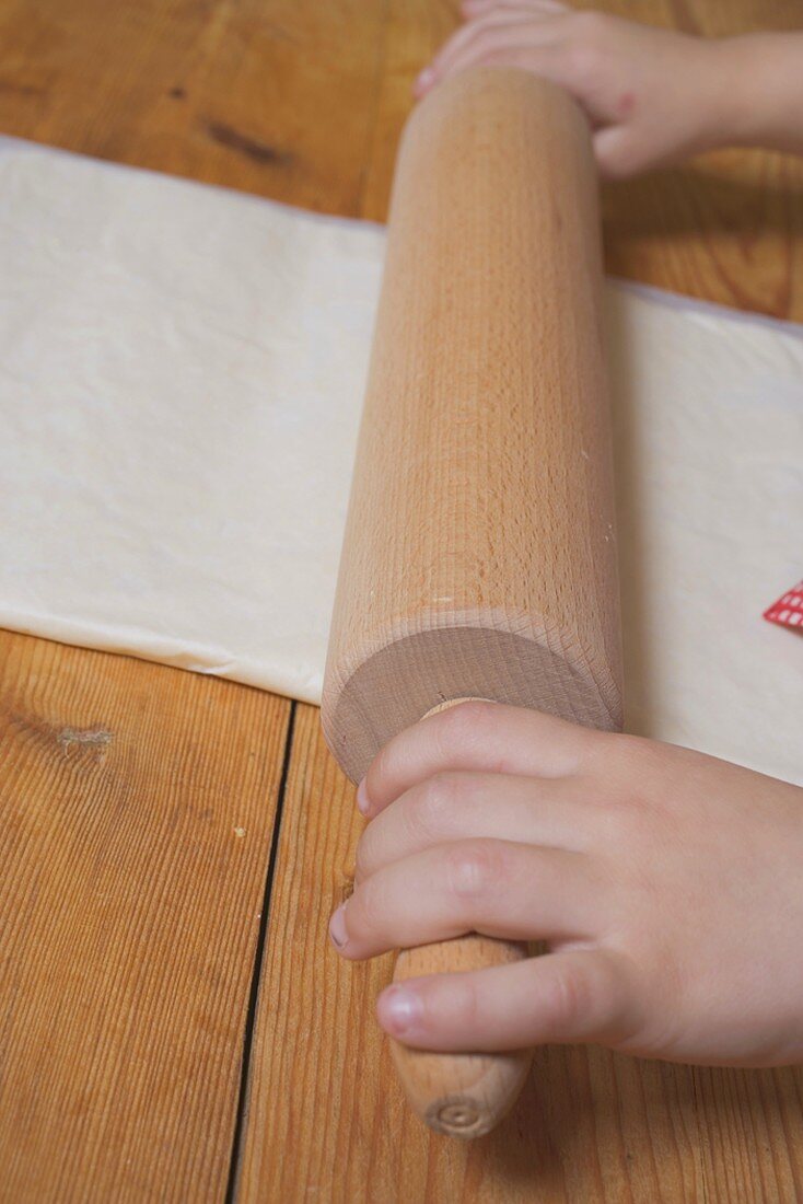 Child's hands rolling out puff pastry