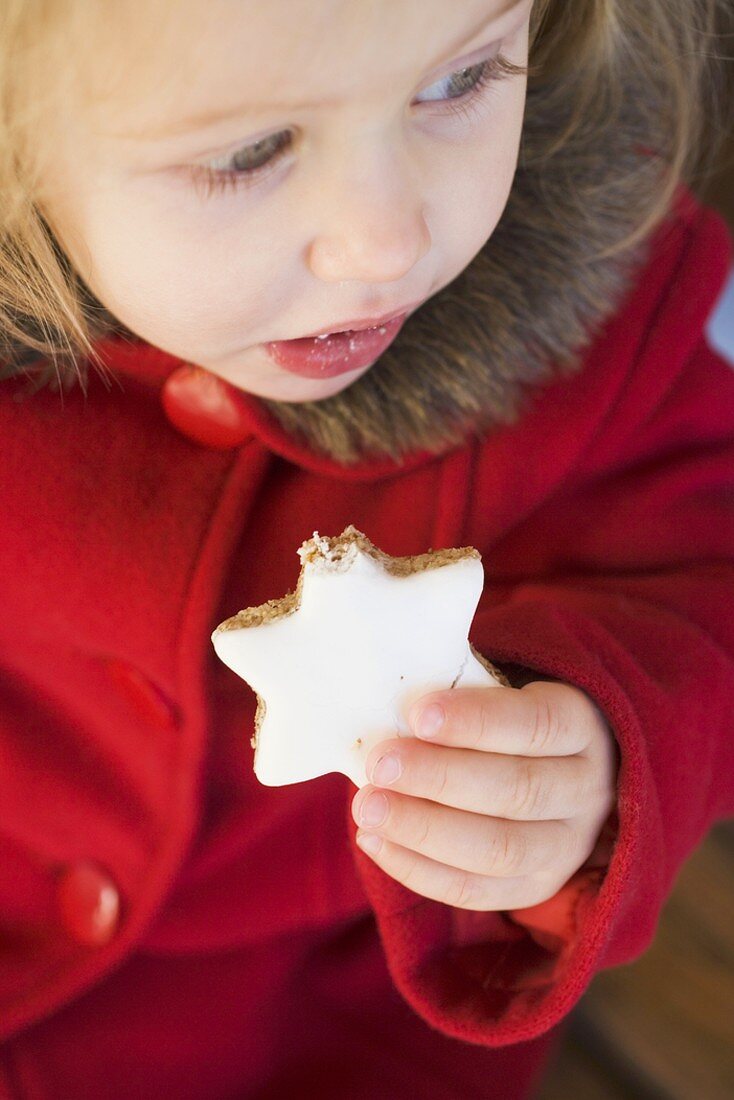 Small girl eating cinnamon star