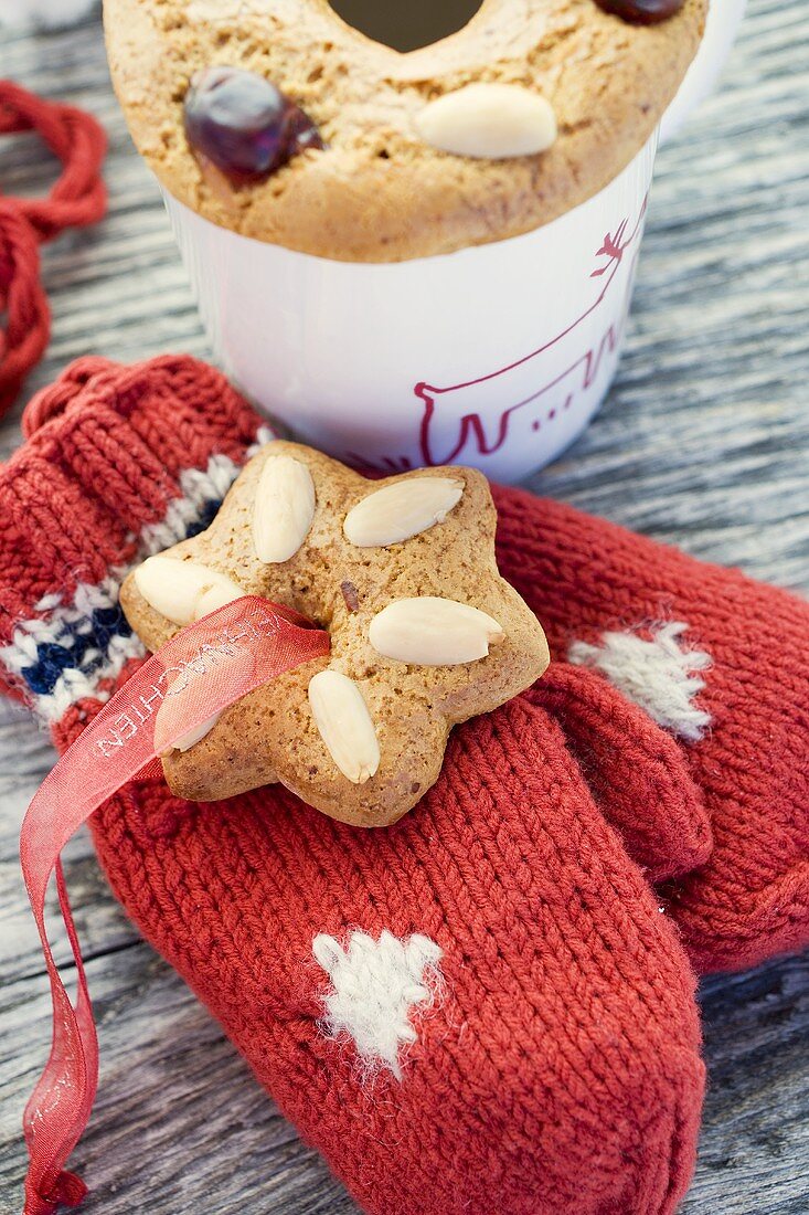 Gingerbread tree ornaments on woollen mittens and cup