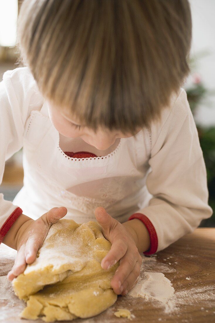 Small boy kneading dough