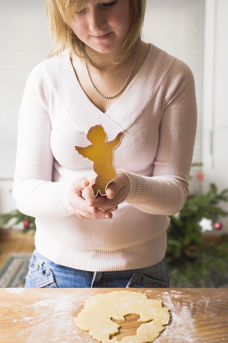 Frau sticht Weihnachtsplätzchen aus