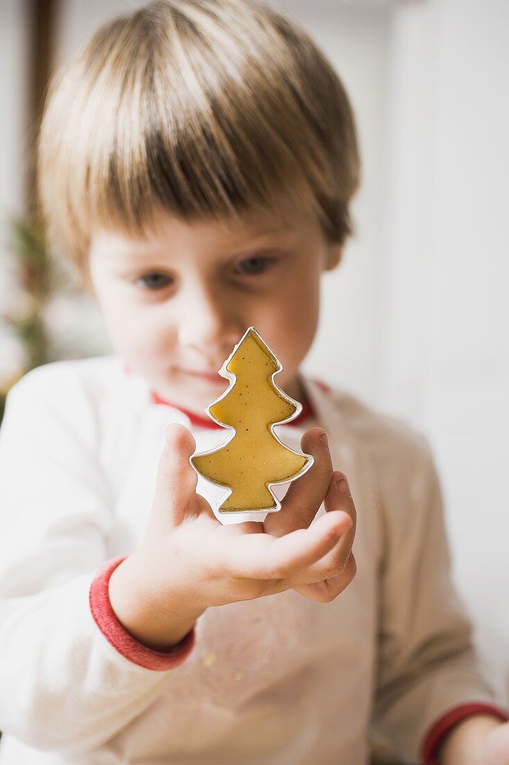 Small boy cutting out a biscuit