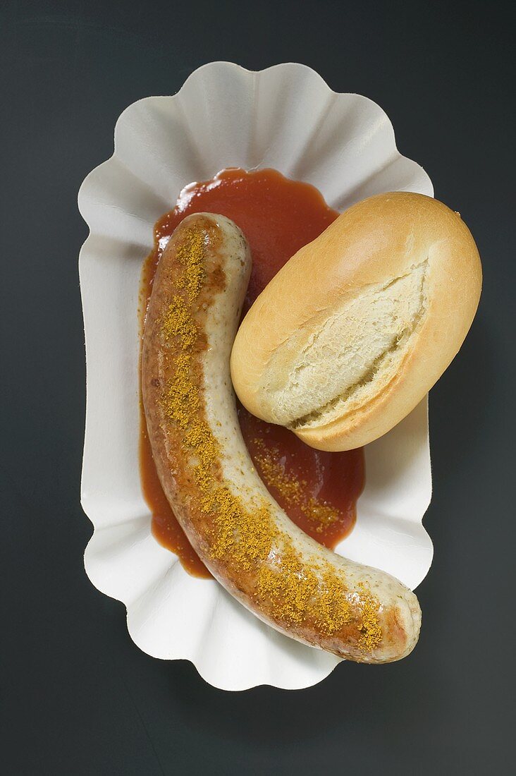 Bratwurst mit Curry, Ketchup und Brötchen (Draufsicht)