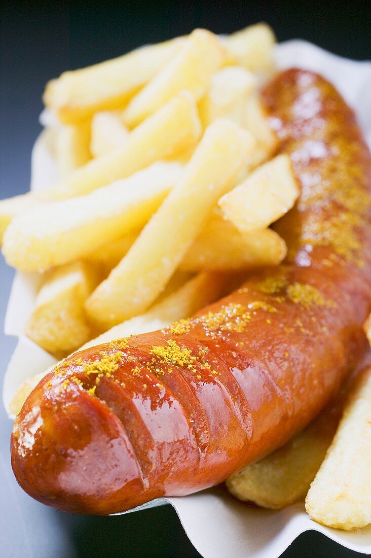Currywurst (sausage with ketchup & curry powder) & chips in paper dish