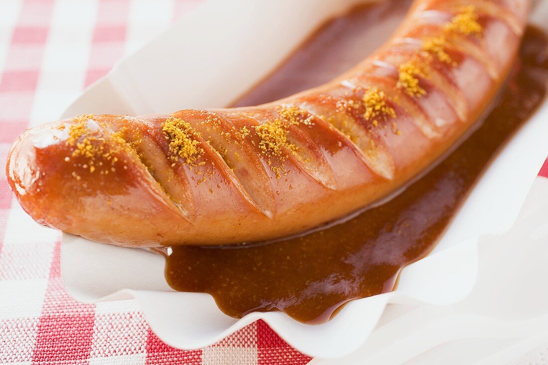 Currywurst mit Ketchup auf Pappteller