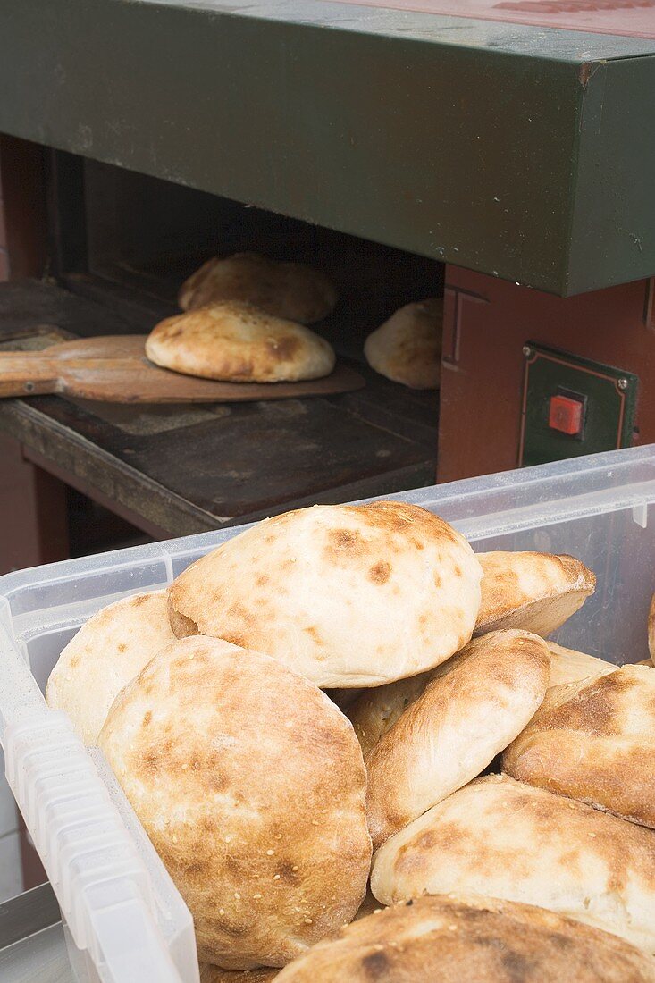 Pita bread in the oven and in a plastic crate