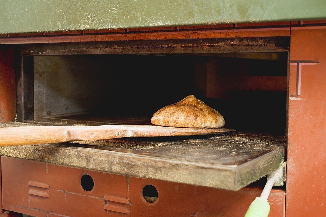 Pita bread on wooden peel in oven