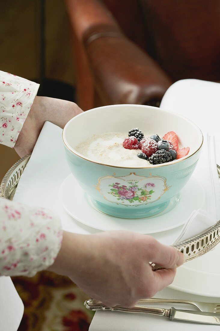 Hände servieren Tablett mit Porridge