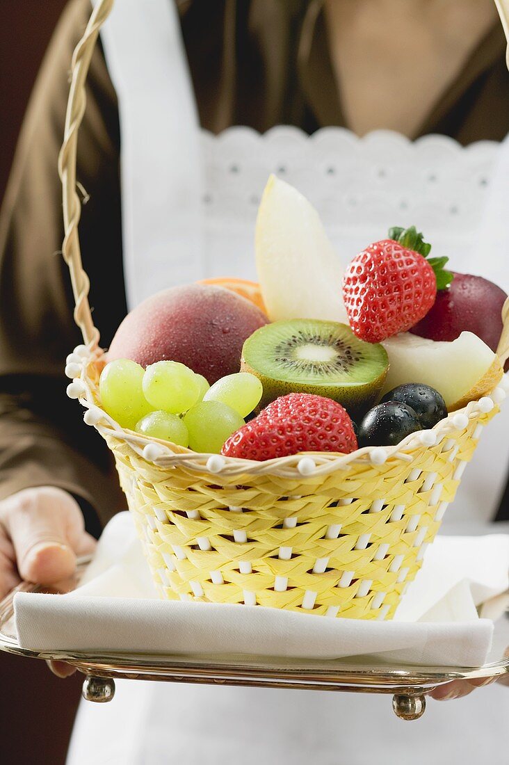 Waitress serving a basket of fruit