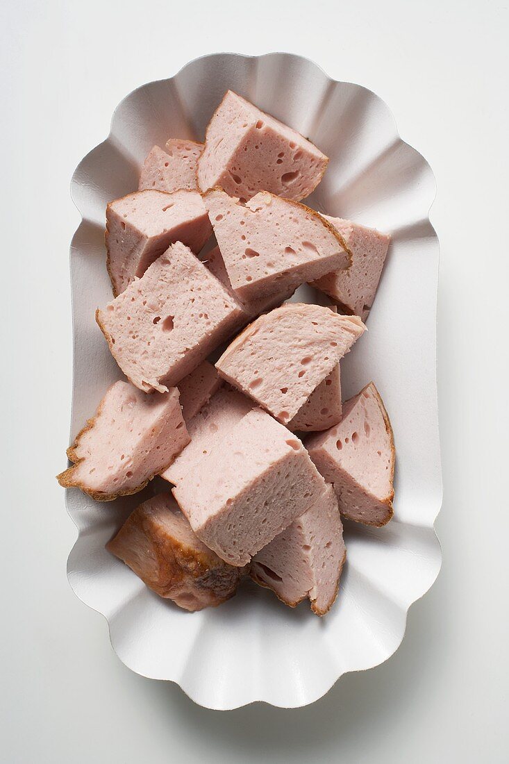 Pieces of Leberkäse (a type of meatloaf) in paper dish