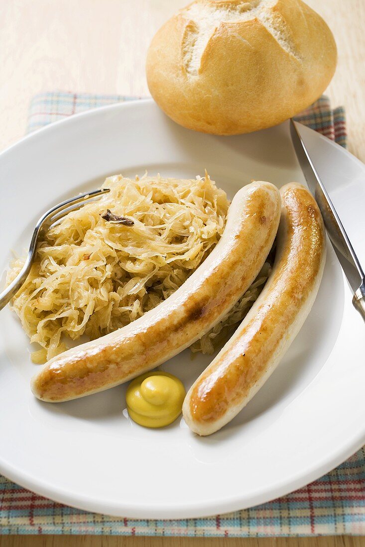 Grillwürste mit Sauerkraut, Senf und Brötchen