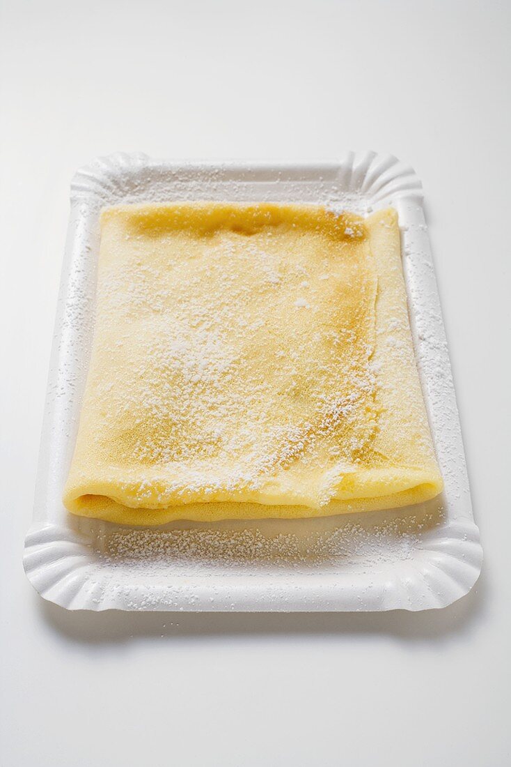 Crepe mit Puderzucker auf Pappteller