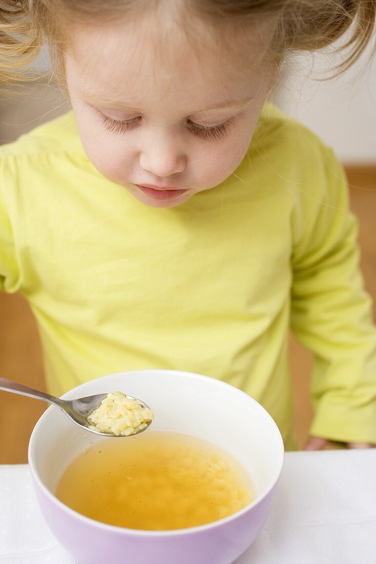 Kleines Mädchen isst Nudelsuppe