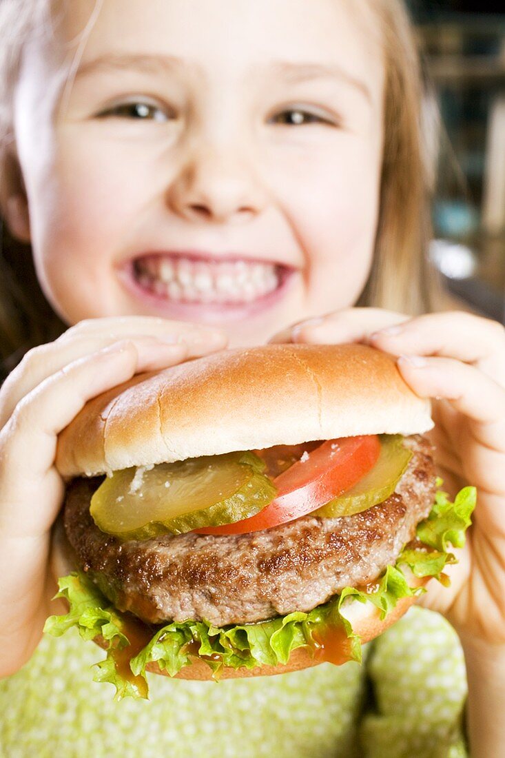 Girl holding large hamburger