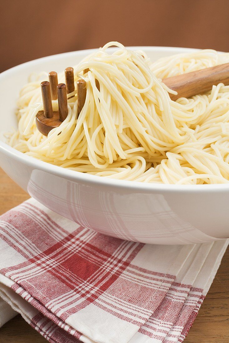 Spaghetti mit Spaghettiheber in grosser Schüssel