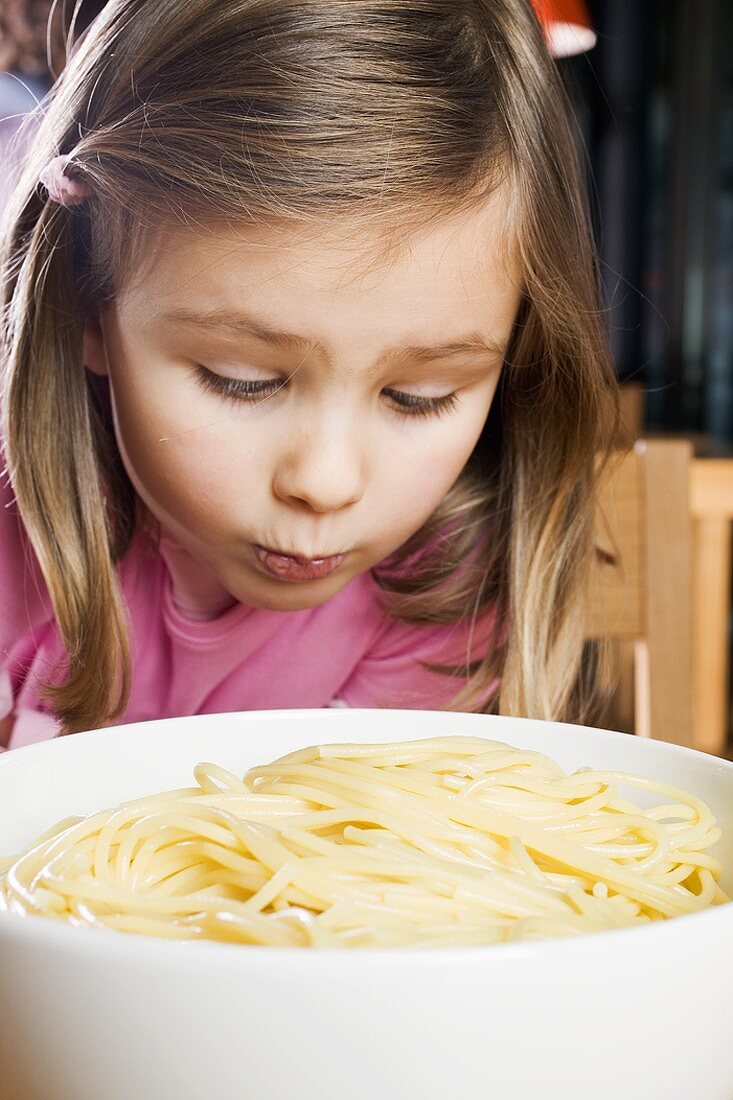 Girl looking sadly at cooked spaghetti
