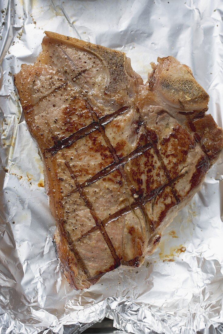Grilled T-bone steak on aluminium foil