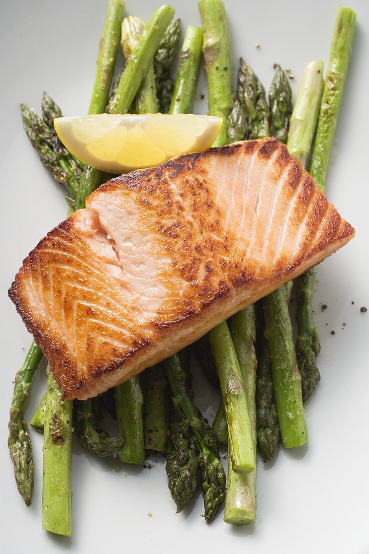 Fried salmon fillet on green asparagus