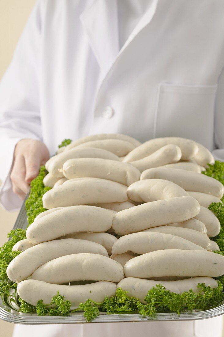 Person holding tray of Weisswurst (white sausages)
