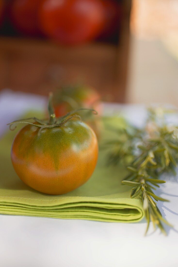 Green tomatoes on green napkin on table out of doors