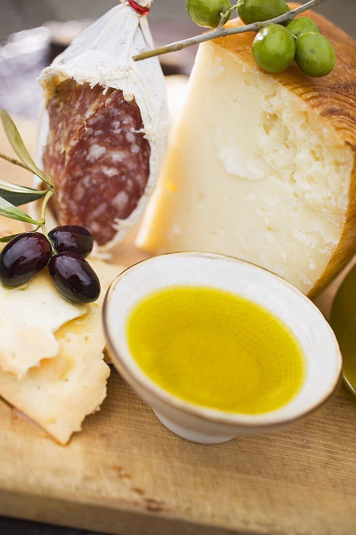 Oliven, Cracker, Olivenöl, Parmesan und Salami