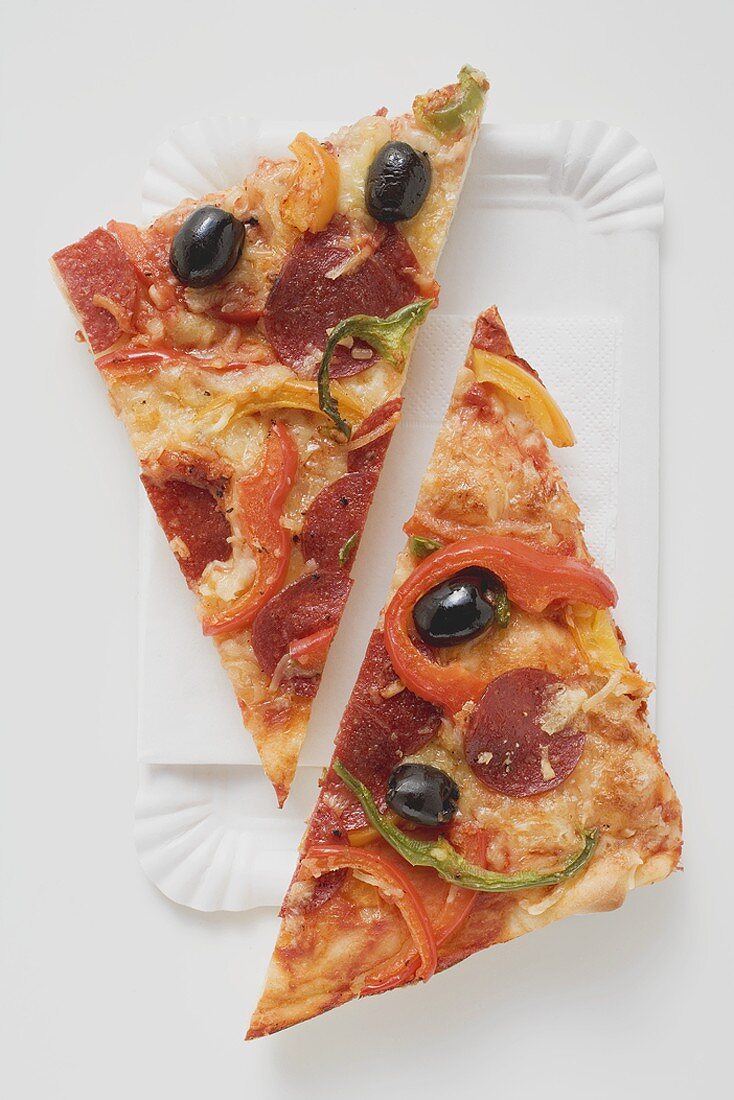 Stück Pizza mit Peperoniwurst, Paprika und Oliven (halbiert)