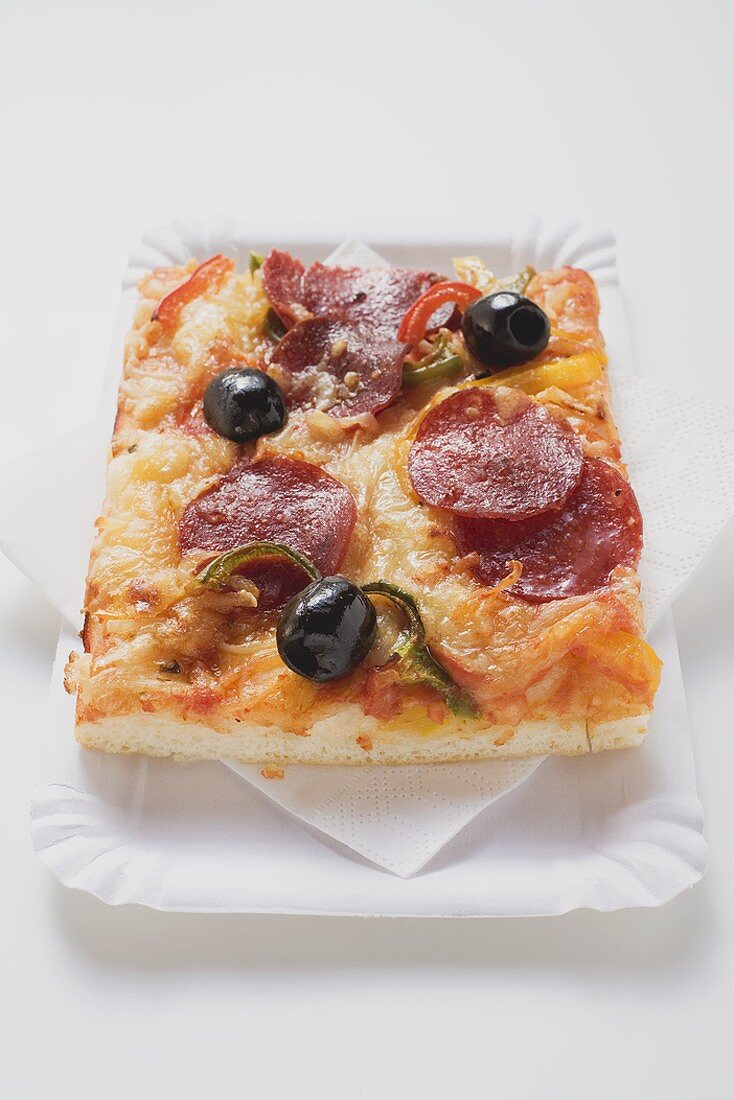 Slice of pepperoni pizza with peppers and olives