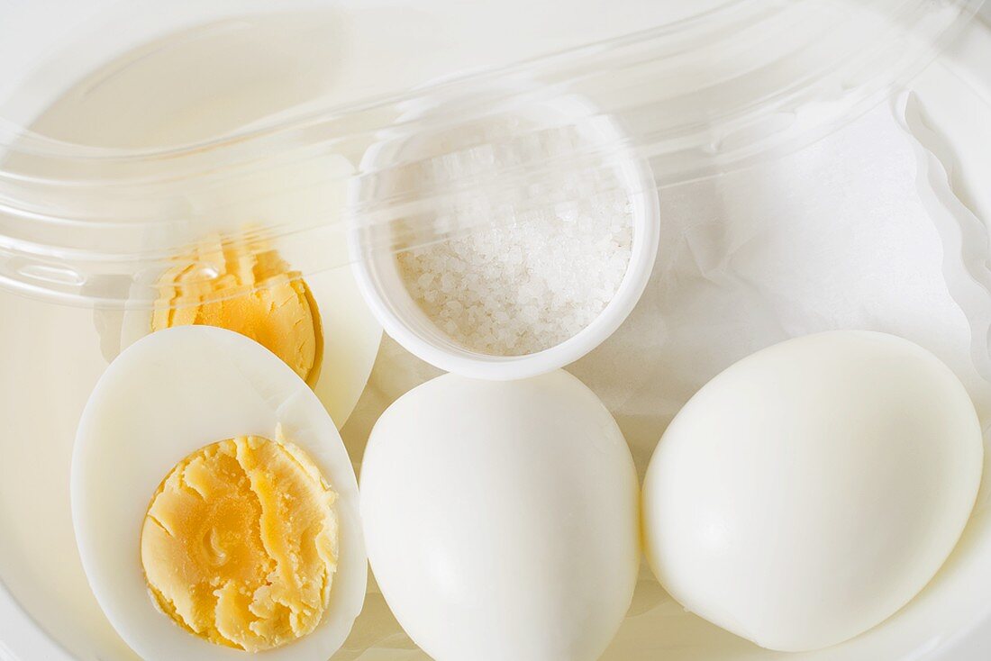 Boiled eggs and salt in plastic food storage container