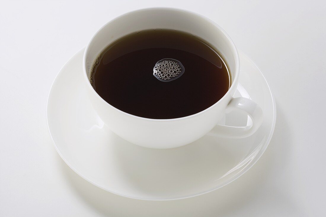 Black coffee in white cup and saucer