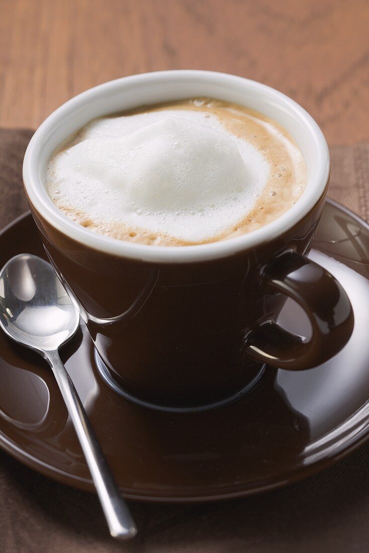 Cappuccino in brown cup and saucer