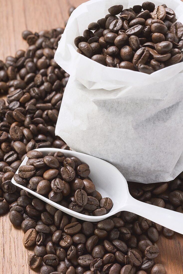 Kaffeebohnen, teilweise in Sack und Schaufel