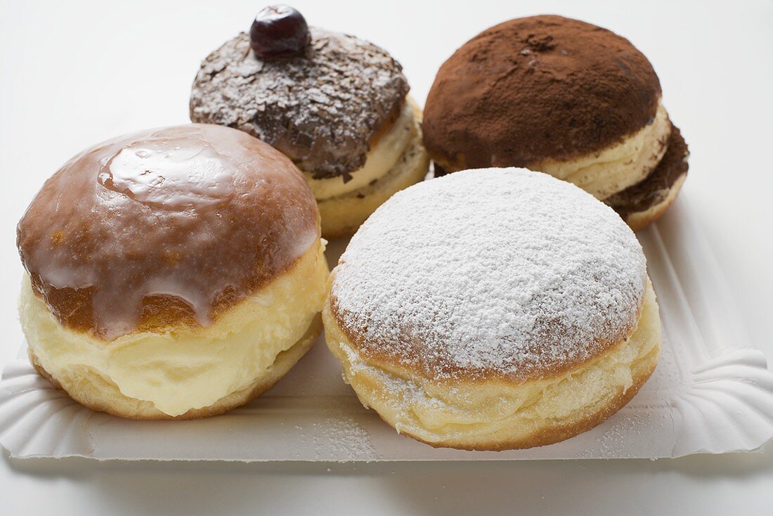 Four different doughnuts on paper plate