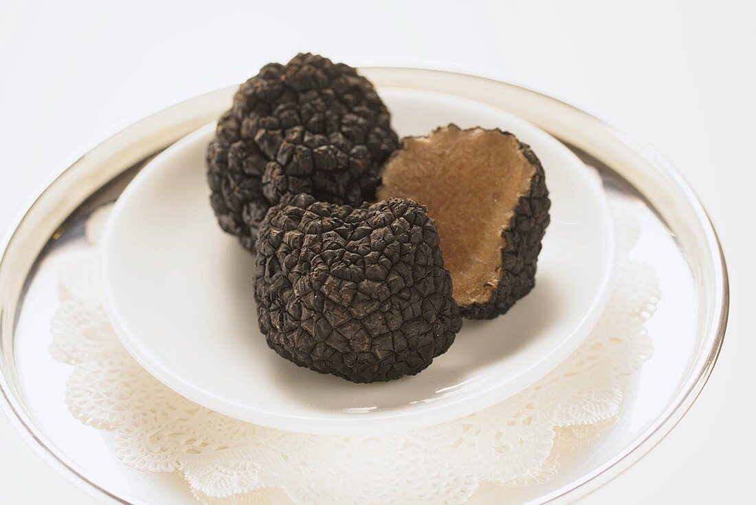 Black truffles, whole and halved, on plate