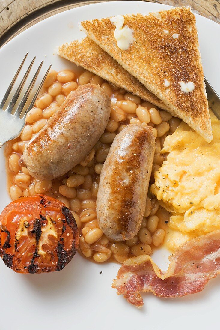 Baked beans with scrambled egg, sausages, bacon, tomato & toast