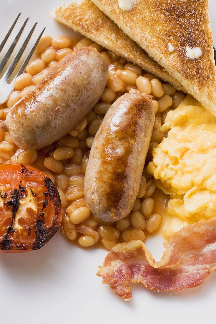 Baked beans with sausages, scrambled egg, bacon, tomato, toast
