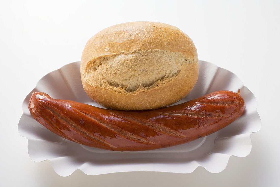 Sausage (bratwurst) and baguette roll in paper dish