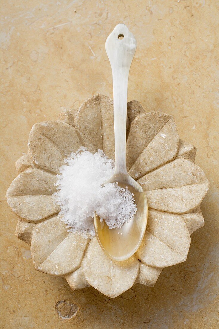 Fleur de sel in spoon in flower-shaped dish