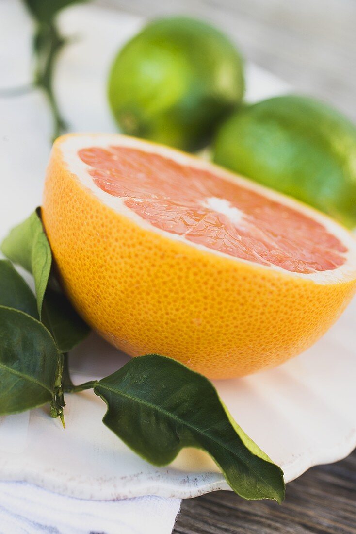 Half a pink grapefruit, limes in background