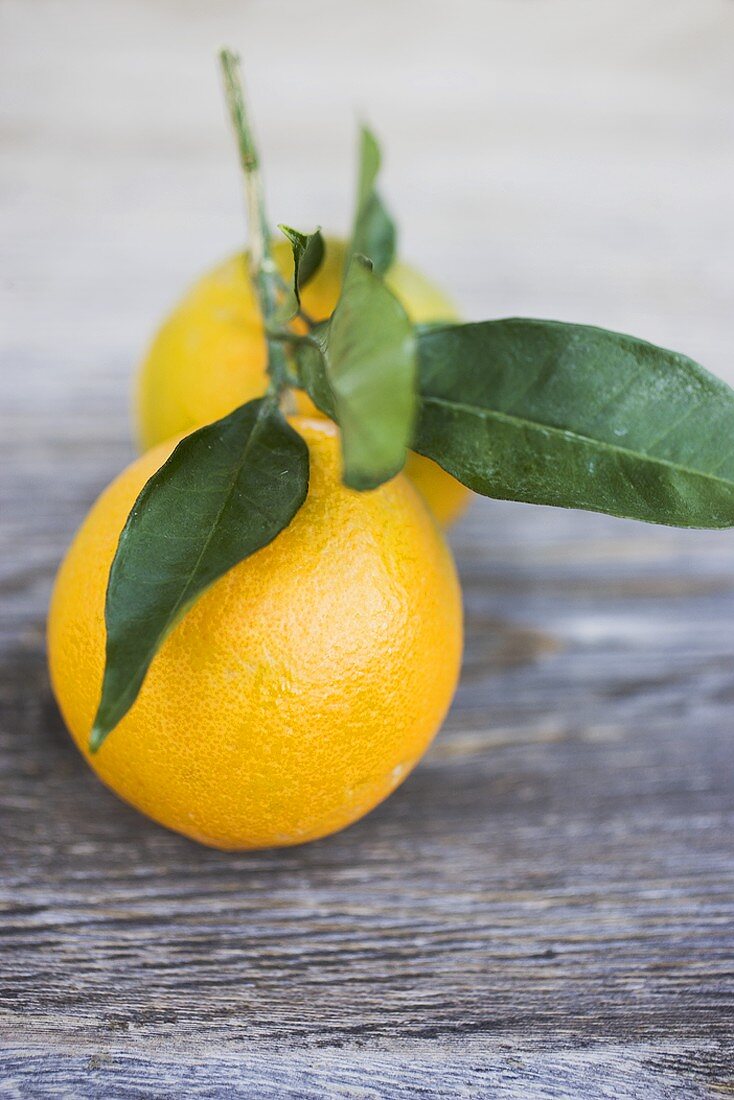 Oranges with leaves on wooden background