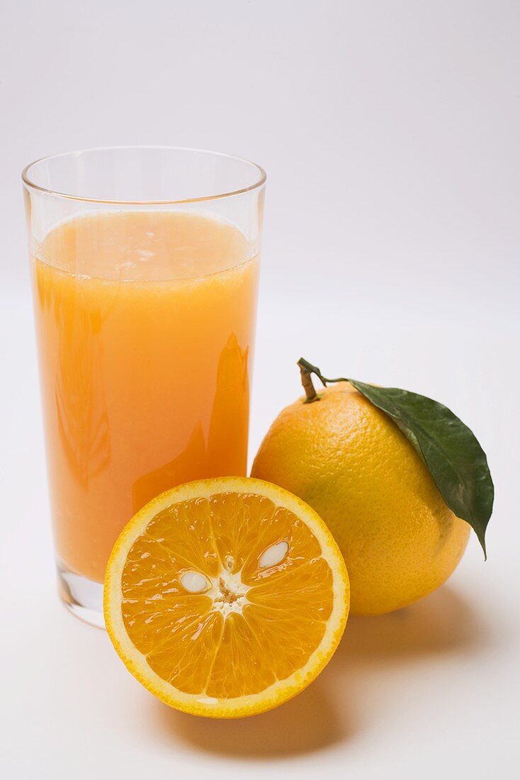 Glass of orange juice and oranges