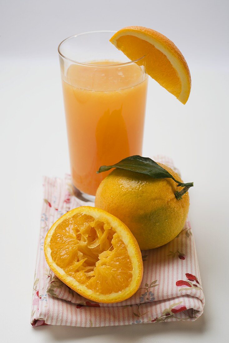 Glass of orange juice and oranges