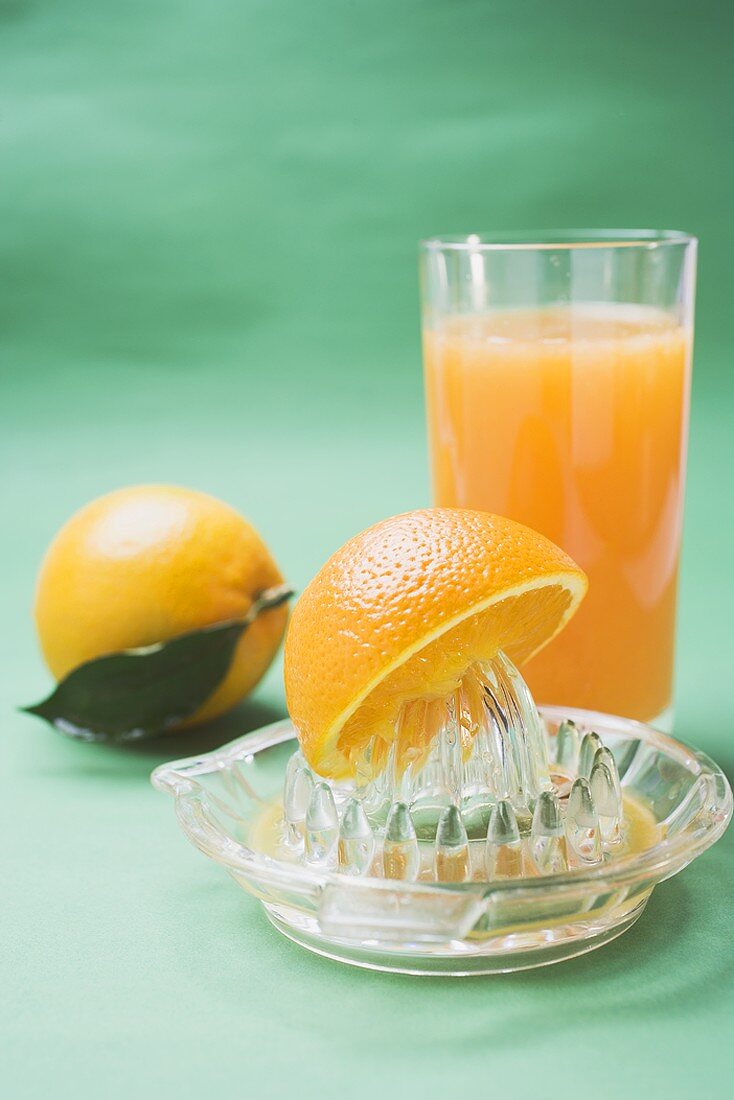 Glas Orangensaft, Orangen und Saftpresse