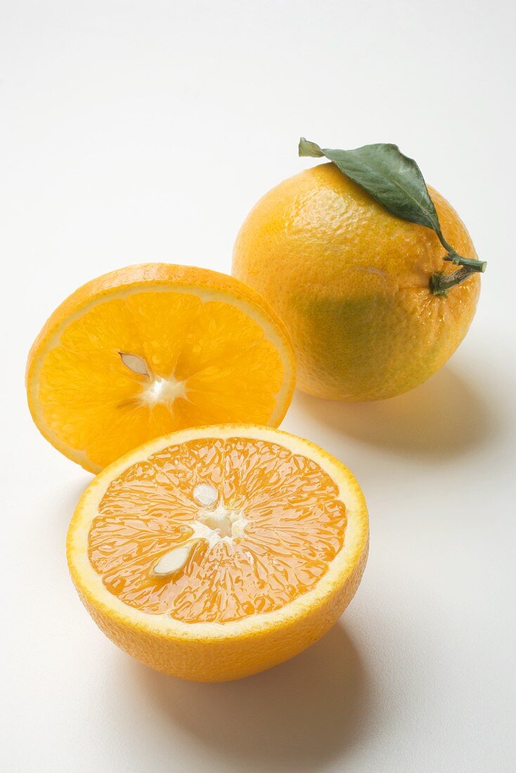 Slice of orange, whole orange with leaf and orange half