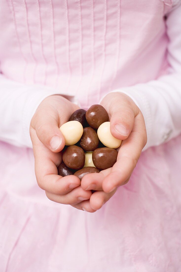 Child's hands holding chocolate eggs