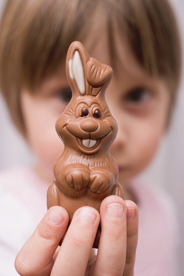 Kind hält Schokoladenosterhasen